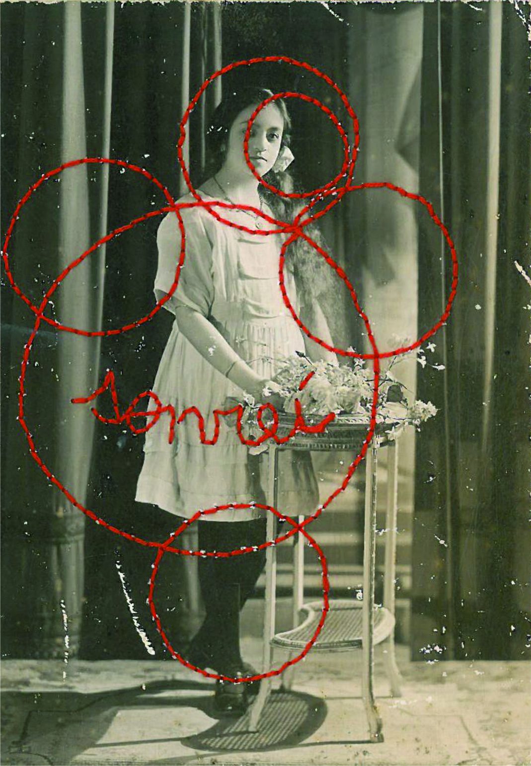 Obra de Emilia Carrión: fotografía antigua bordada con hilo rojo y la palabra “sonreí”